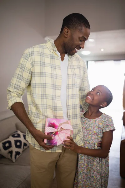 Padre e hija sosteniendo caja de regalo en casa —  Fotos de Stock