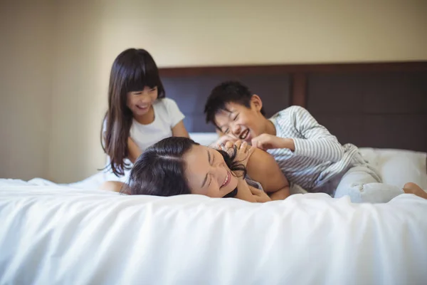 Família se divertindo na cama no quarto da cama — Fotografia de Stock