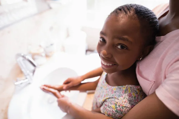 Moeder van meewerkende dochter tijdens het wassen van de handen — Stockfoto