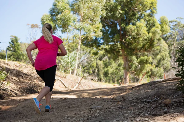 Donna che fa jogging nel campo di addestramento — Foto Stock