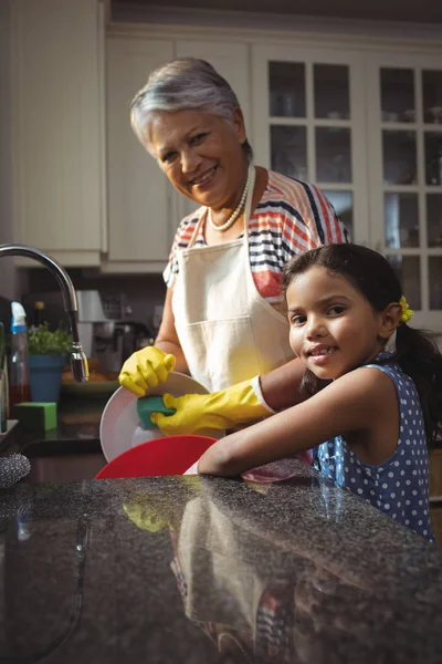 Abuela y nieta lavando utensilios —  Fotos de Stock