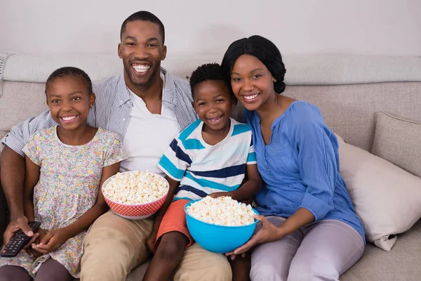 Kanepeye siting ailesi popcorn ile kase — Stok fotoğraf