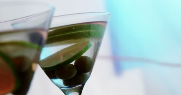 Lemon slices and olives in the glass of cocktail — Stock Video