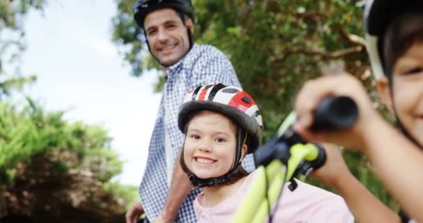 Père et enfants debout avec vélo — Video