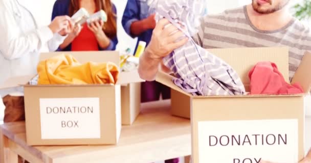 Executive holding clothes in donation box — Stock Video