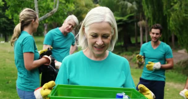 Mujer mayor sosteniendo una papelera de reciclaje — Vídeos de Stock