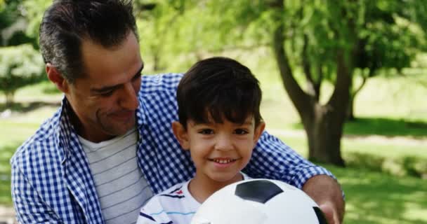 Pai e filho sentados no parque — Vídeo de Stock