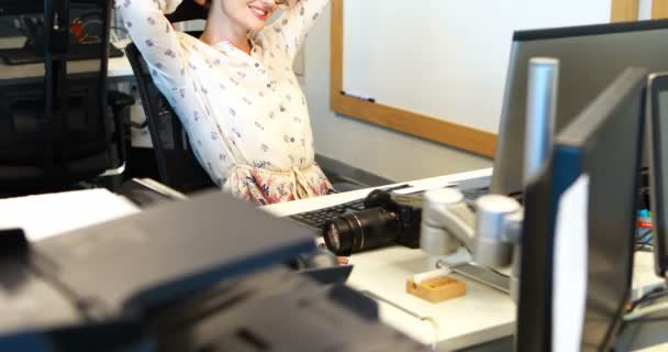 Female graphic designer relaxing at desk — Stock Video