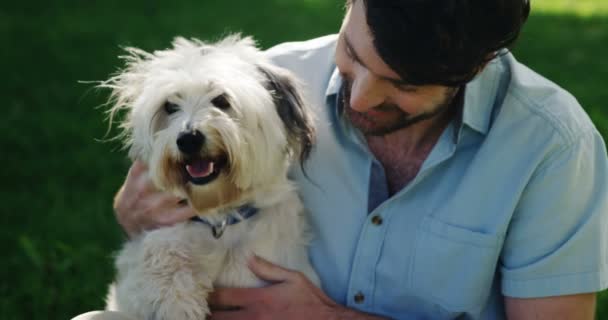 Man leker med sin hund i parken — Stockvideo