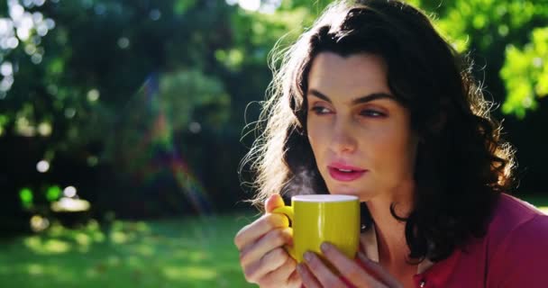 Frau trinkt Kaffee im Garten — Stockvideo