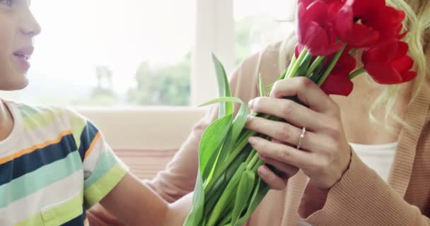 Son med massa blommor till mor — Stockvideo