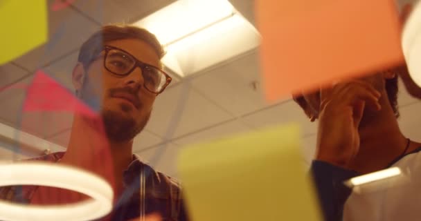 Business colleagues discussing over sticky notes — Stock Video