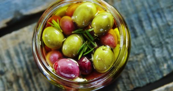 Маринованные оливки и травы в банке — стоковое видео