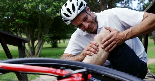 Fallen cyclist holding his injured knee — Stock Video