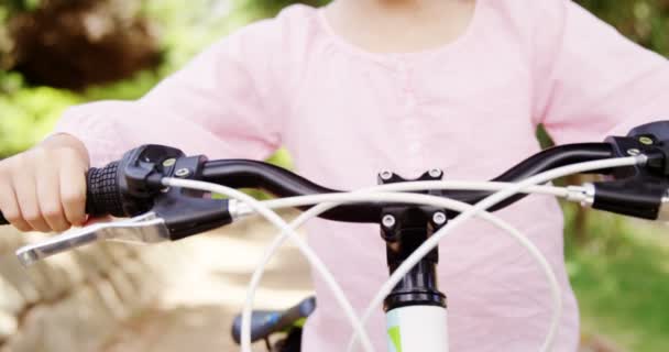 Smiling girl standing with bicycle — Stock Video