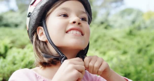 Fille souriante portant un casque dans le parc — Video