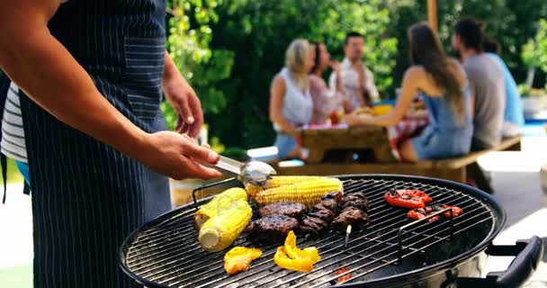 Man grilling corn, meat and vegetables — Stock Video