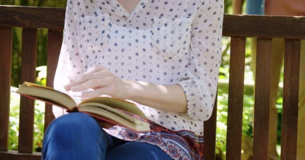 Beautiful woman reading book in park — Stock Video