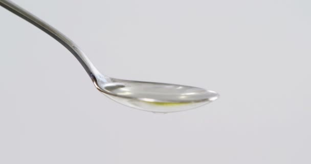 Aceituna verde cayendo sobre cuchara con aceite de oliva — Vídeo de stock