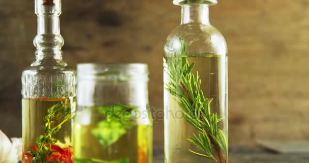 Frascos y botellas con aceite de oliva y hierbas — Vídeo de stock