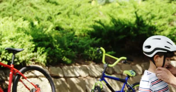 Πατέρας βοηθώντας γιος φορώντας κράνος ποδηλάτου — Αρχείο Βίντεο