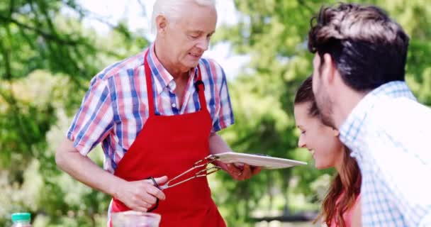 Senior Mann serviert seiner Familie Essen — Stockvideo