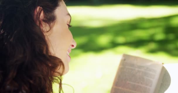 Libro de lectura de mujer en jardín — Vídeos de Stock