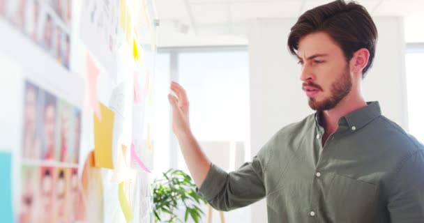 Executive reading sticky notes on glass wall — Stock Video