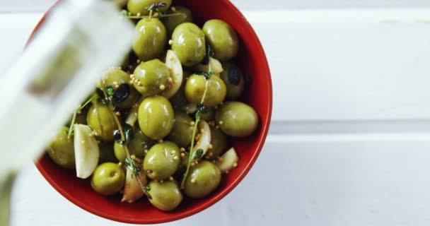 Aceite de oliva que se vierte en tapas de oliva verde — Vídeo de stock