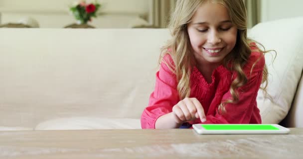 Κορίτσι χρησιμοποιώντας ψηφιακό tablet στο σαλόνι — Αρχείο Βίντεο