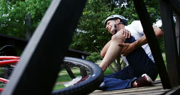 Cycliste tombé tenant son genou blessé — Video