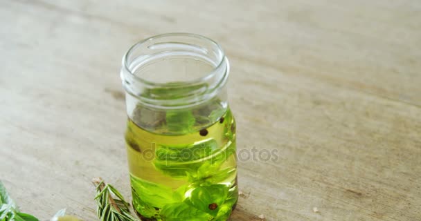 Оливки, оливковое масло и травы на столе — стоковое видео
