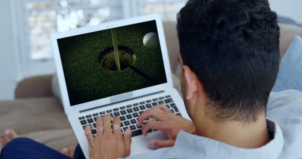 Seorang pria menonton golf di laptop di ruang tamu — Stok Video