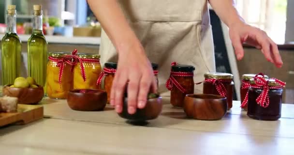Жіночий персонал організовує оливки, консерви та оливкову олію на стійці — стокове відео
