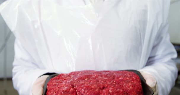 Female butcher holding a tray of raw meat — Stock Video