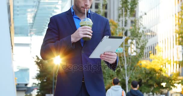 Homme d'affaires utilisant une tablette numérique tout en ayant du jus — Video