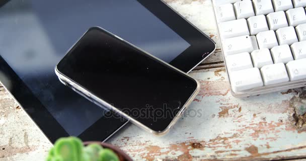 Tableta digital, teléfono móvil, maceta en tablón de madera — Vídeos de Stock