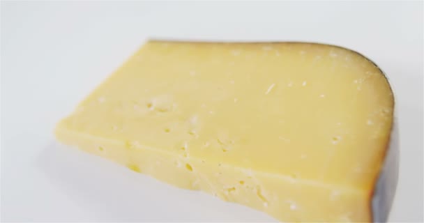 Кусок сыра на белом фоне — стоковое видео