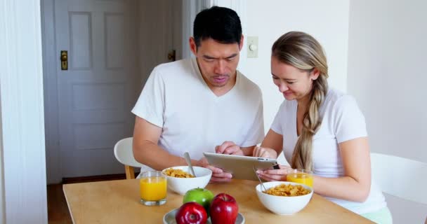 Casal feliz usando tablet digital enquanto toma café da manhã — Vídeo de Stock