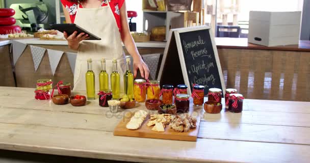 Personal femenino que organiza aceitunas, conservas y aceite de oliva en el mostrador — Vídeos de Stock