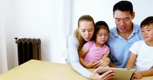Счастливая семья с помощью цифрового планшета в гостиной — стоковое видео