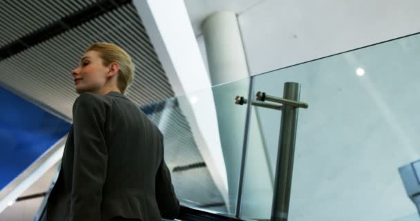 Businesswoman standing on an escalator — Stock Video