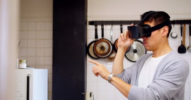 Человек с гарнитурой виртуальной реальности на кухне — стоковое видео