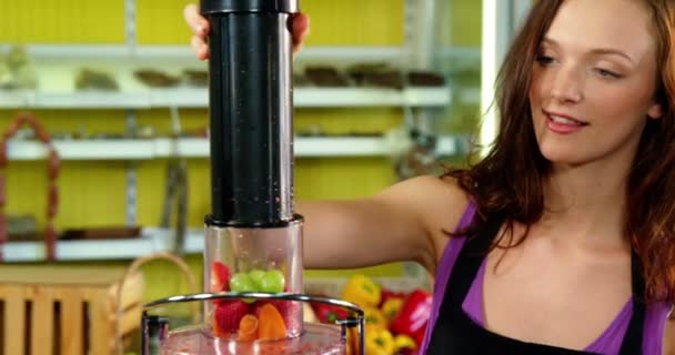 Készül a friss gyümölcslé gyümölcscentrifuga a női alkalmazottak — Stock videók
