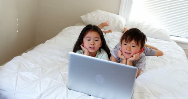 Niños usando portátil en la cama — Vídeos de Stock
