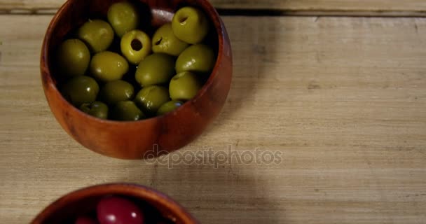 Aceitunas rojas y verdes guardadas en un recipiente en el mostrador — Vídeo de stock