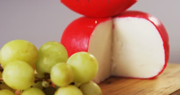 Queijo vermelho e uvas em tábua de madeira — Vídeo de Stock