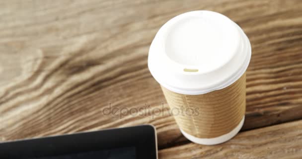 Tazza di caffè usa e getta, tablet digitale, telefono cellulare, carta di credito su tavola di legno — Video Stock