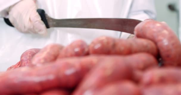 Mujer carnicera cortando salchichas — Vídeos de Stock