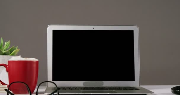 笔记本电脑，眼镜，杯咖啡和一摞书 — 图库视频影像